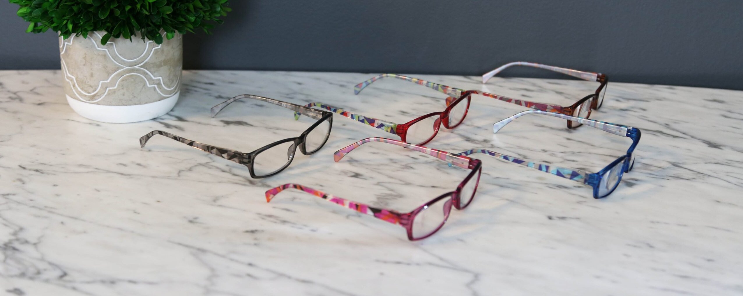 5 pairs of reading glasses on table