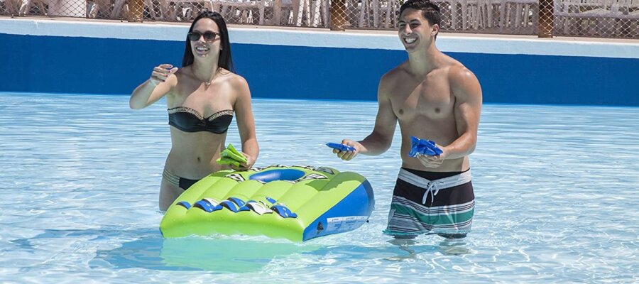 adults playing pool cornhole