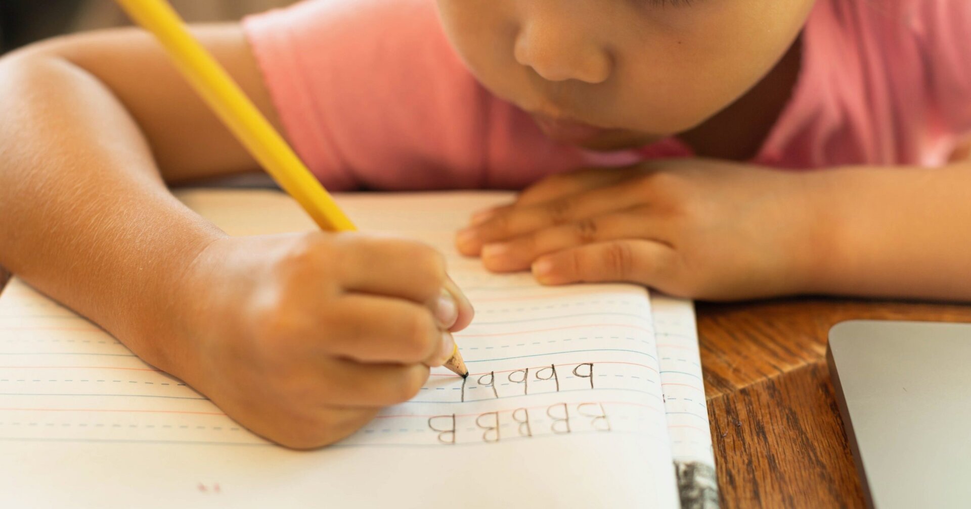 child writing on handwriting paper