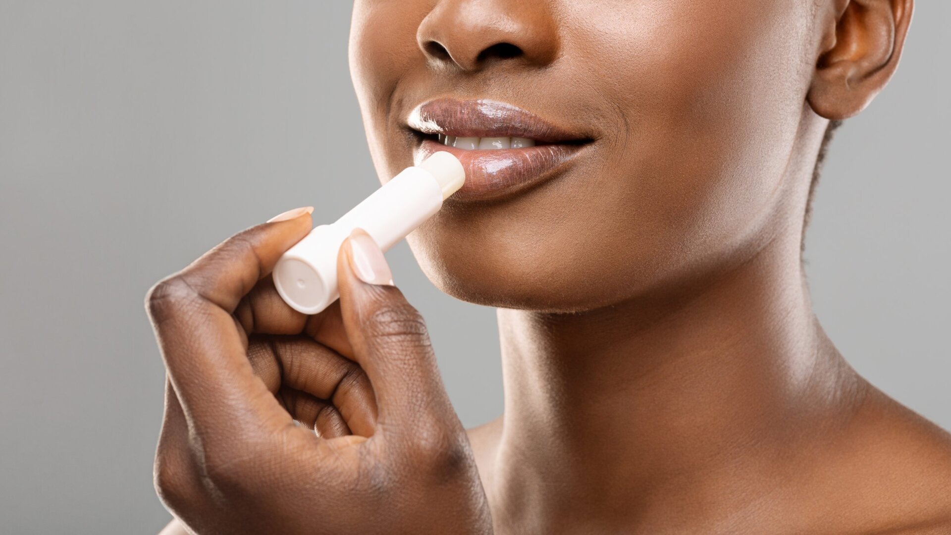 woman putting on lip balm