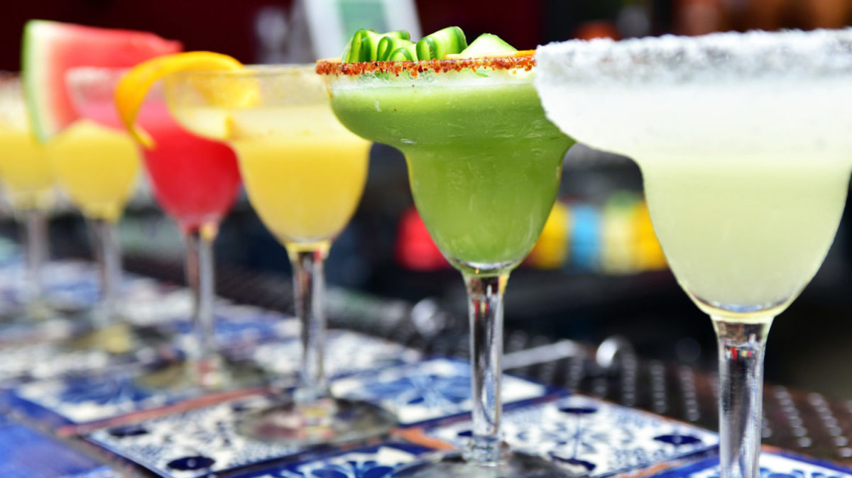 Row of margaritas in glasses on bar