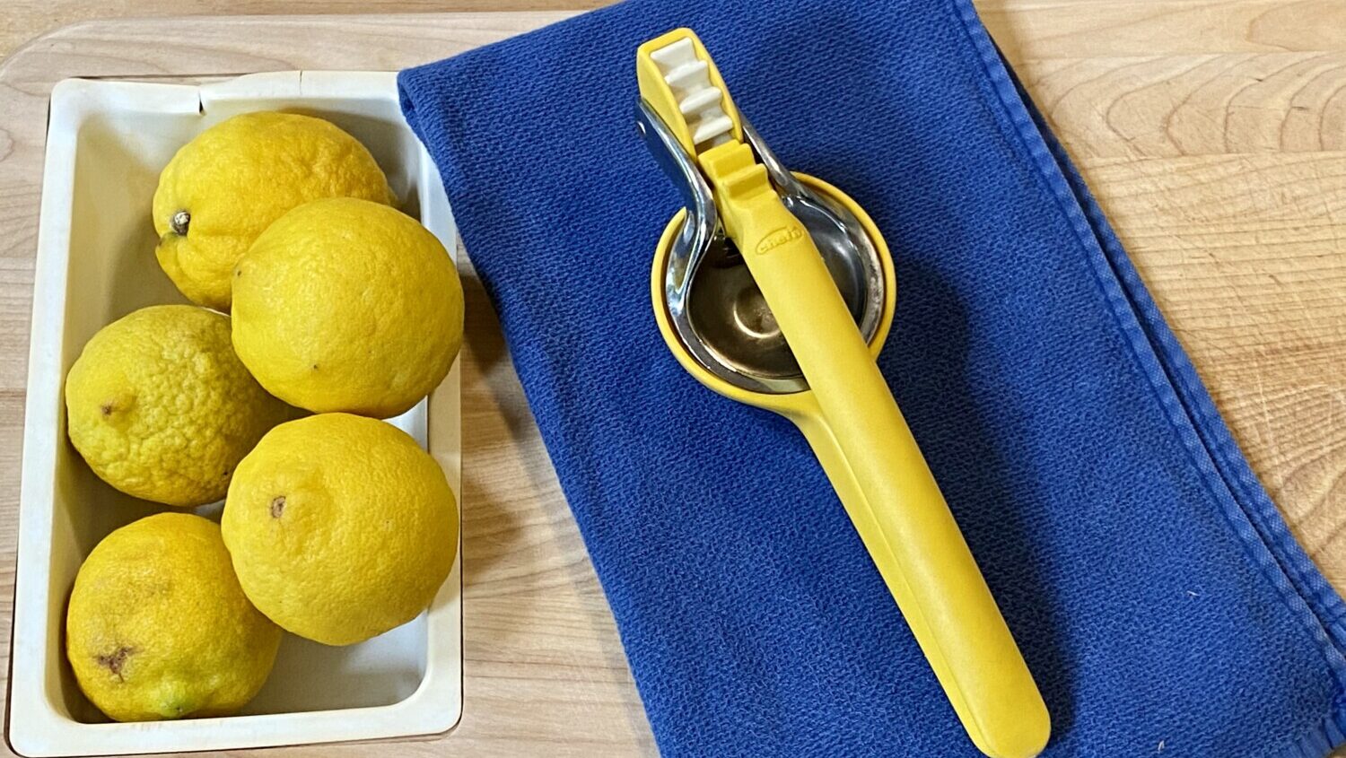 Chef'n FreshForce citrus juicer on blue towel next to lemons