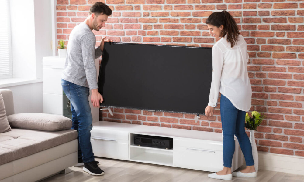 Couple moves television in living room