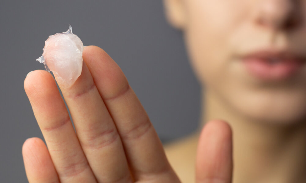 woman applying petroleum jelly to her face.