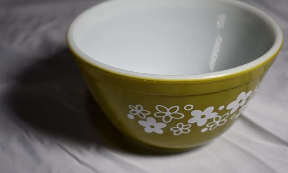 Green Pyrex bowl on white tablecloth