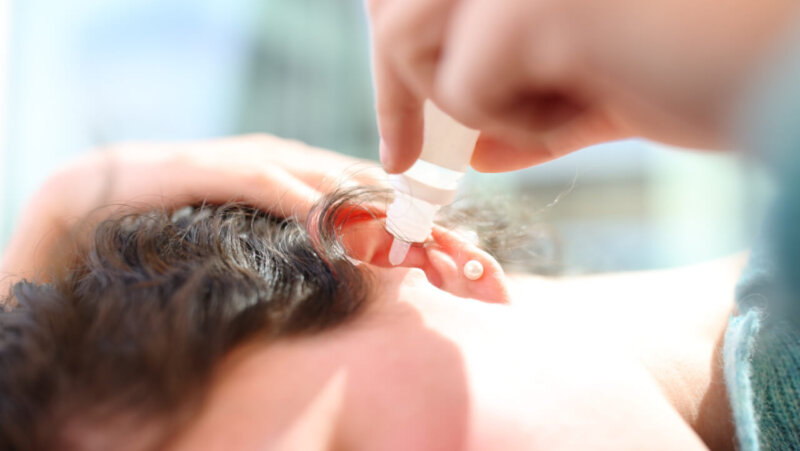 Woman applying ear drops